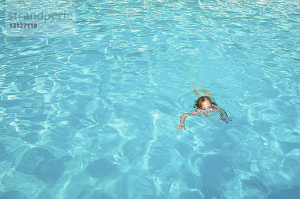 Mädchen schwimmt an einem sonnigen Tag im Pool