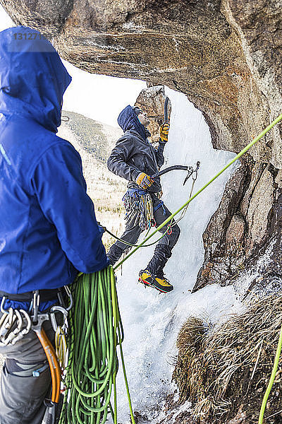 Freunde beim Eisklettern in den Weissen Bergen im Winter