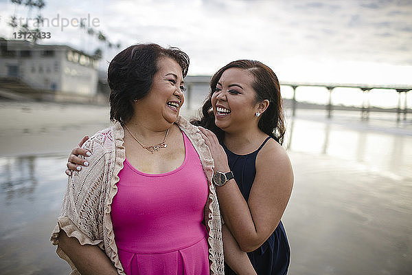 Fröhliche Mutter und Tochter am Strand