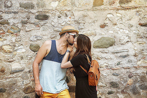 Gegen die Wand küssendes Paar