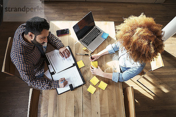 Hochwinkelansicht von Geschäftsleuten  die im Büro am Tisch arbeiten