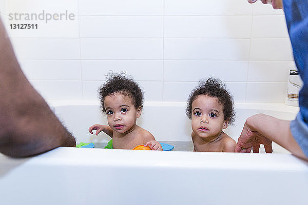 Ausgeschnittenes Bild von Eltern  die ihre Töchter gemeinsam in der Badewanne baden