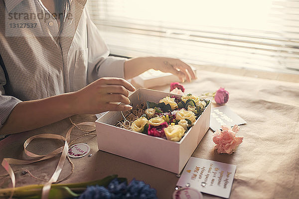 Mittelteil eines Floristen  der Blumen in einer Schachtel arrangiert