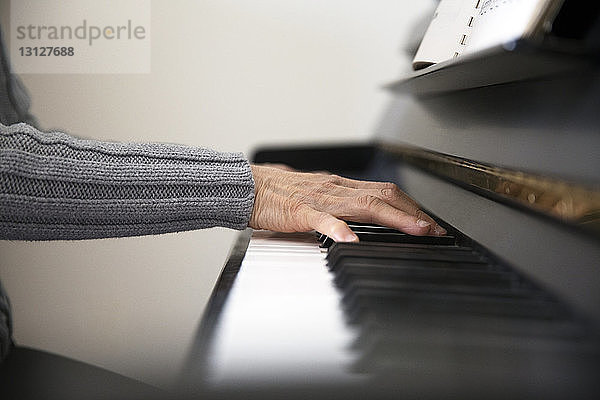 Ausgeschnittenes Bild einer älteren Frau  die zu Hause Klavier spielt