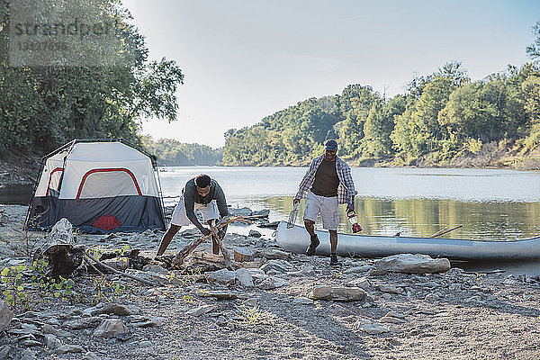 Männliche Freunde genießen auf dem Campingplatz am See