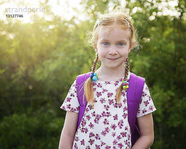Porträt eines selbstbewussten Mädchens mit Rucksack im Park