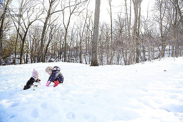 Schwestern spielen auf schneebedecktem Feld