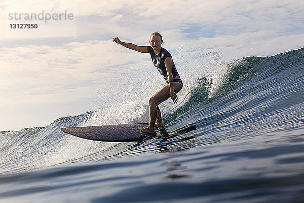 Sorglose Frau beim Surfen auf See