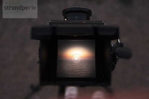 Szenische Ansicht des Meeres bei Sonnenuntergang auf dem Kamerabildschirm