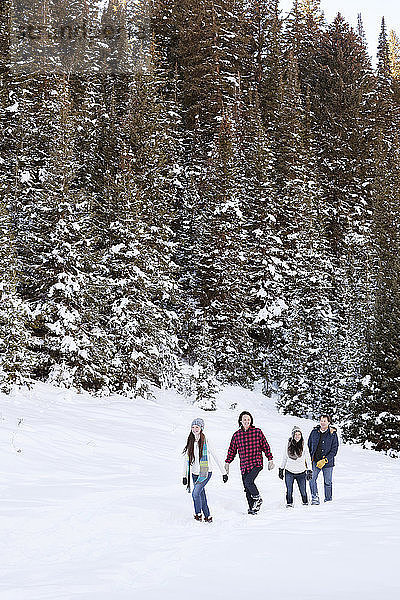 Glückliche Familie beim Spaziergang auf verschneitem Feld