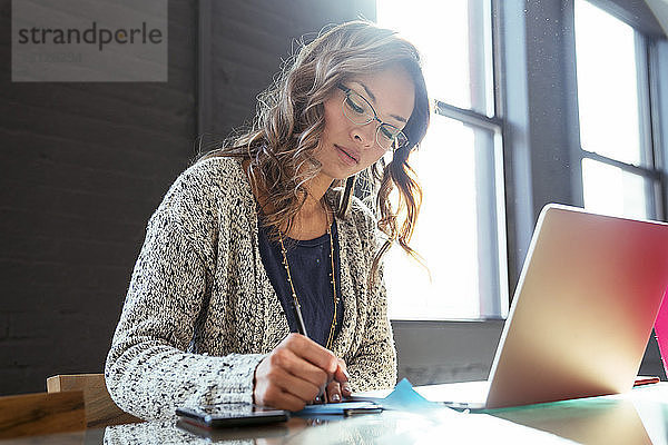Geschäftsfrau mit Laptop-Computer am Schreibtisch im Büro
