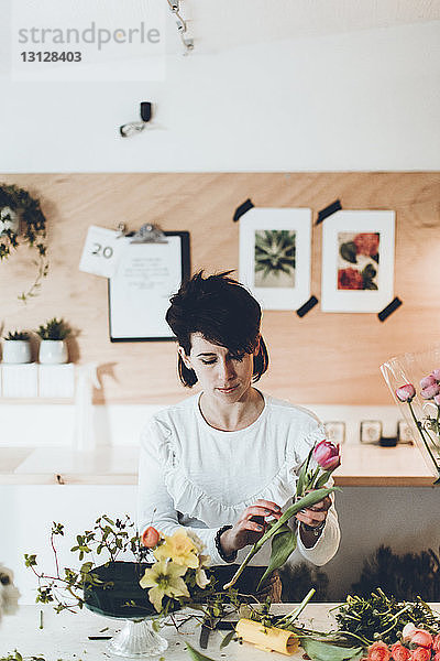 Florist bei Tisch im Blumenladen