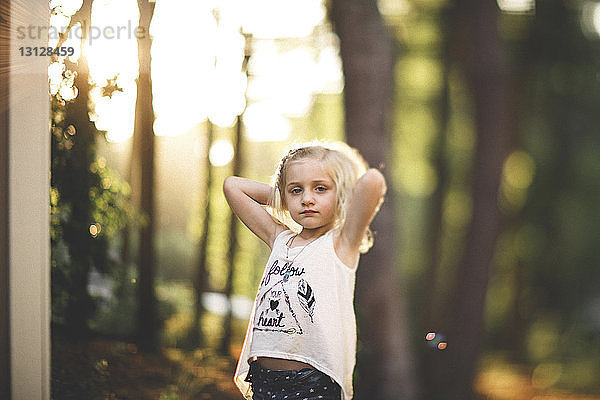 Porträt eines Mädchens  das sich im Hof an Bäumen ausruht