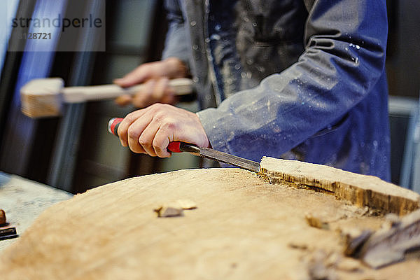 Mittelteil eines männlichen Zimmermanns beim Holzmeisseln in der Werkstatt
