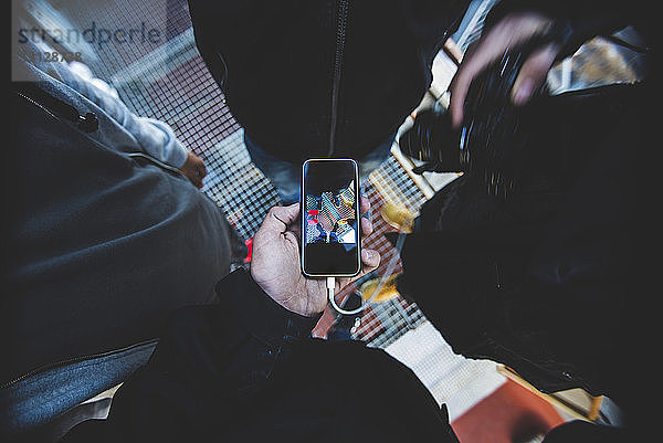 Unterer Teil eines Mannes  der mit Freunden fotografiert  während er im Aufzug steht