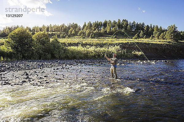 Mann fischt an einem sonnigen Tag im Fluss