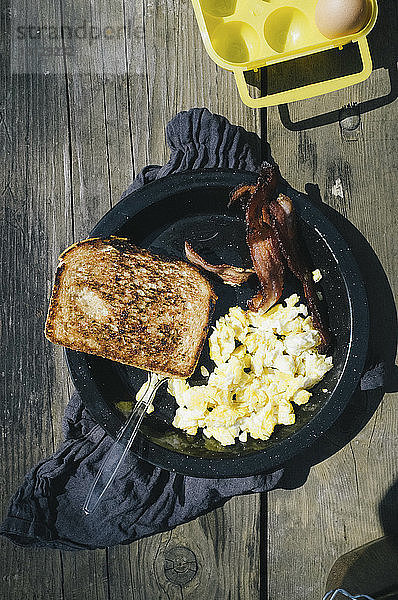 Draufsicht auf das gesunde Frühstück  das in einem Container auf einem Holztisch serviert wird