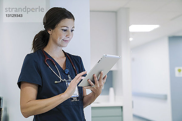 Zuversichtliche Ärztin mit Tablet-Computer im Krankenhaus