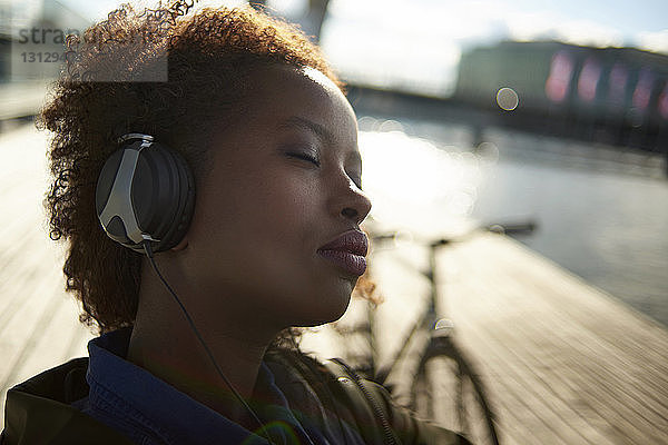Nahaufnahme einer entspannten Frau mit geschlossenen Augen beim Musikhören