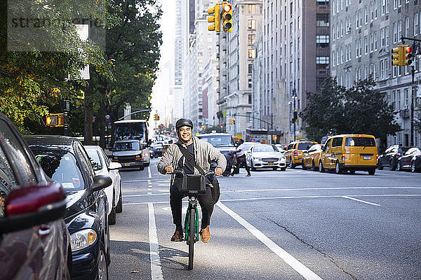 Glücklicher Mann fährt Fahrrad auf der Straße in der Stadt