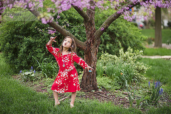 Mädchen tanzt im Frühling im Park am Baum