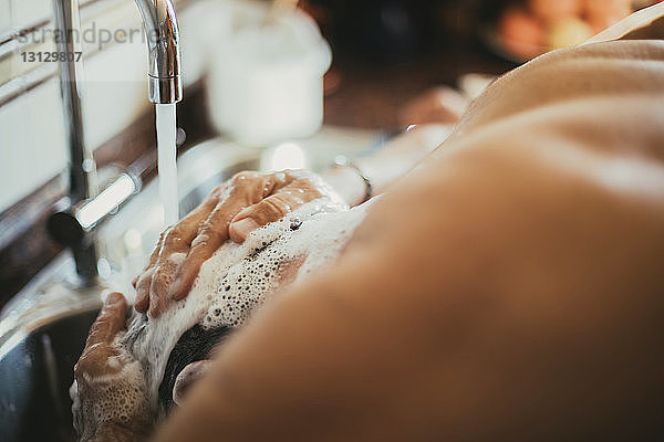 Mann wäscht Haare beim Friseur