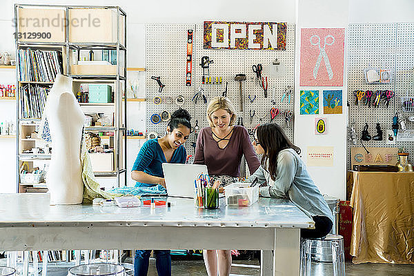 Geschäftsfrauen  die am Laptop im Kreativbüro arbeiten