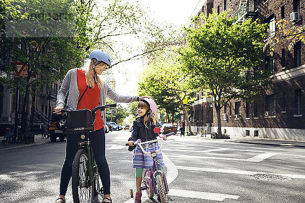 Mutter und Tochter mit Fahrrädern auf der Straße in der Stadt