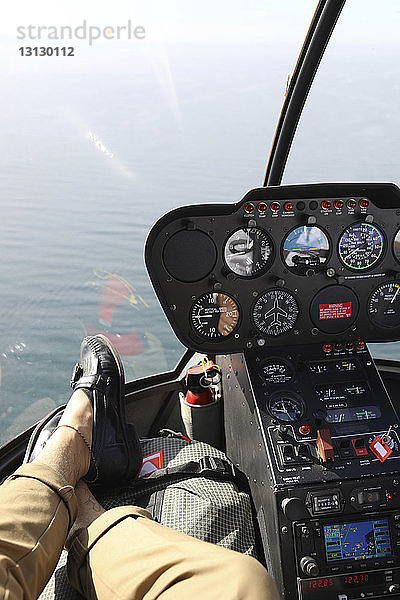 Niedriger Teil des Mannes entspannt sich im Cockpit des Hubschraubers