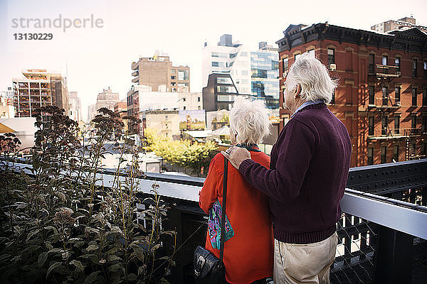 Älteres Ehepaar steht auf Balkon in der Stadt