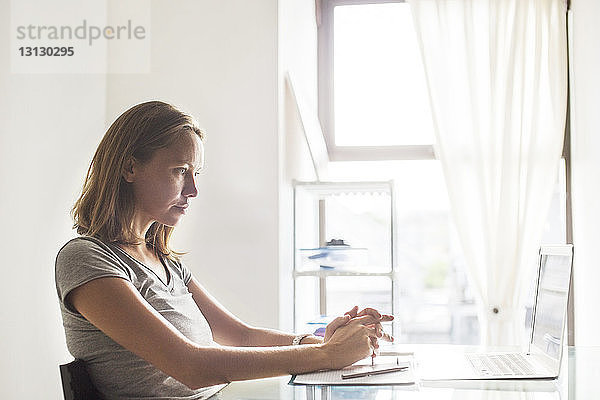 Frau benutzt Laptop zu Hause