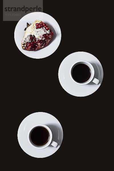 Draufsicht auf Kaffee von Granatapfel in Teller über schwarzem Hintergrund
