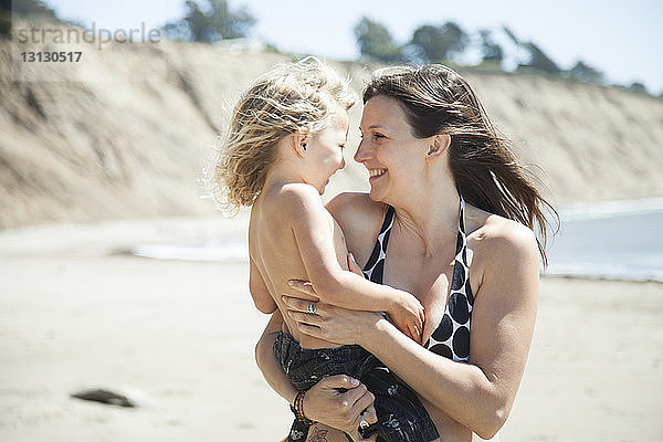 Glückliche Mutter und Tochter am Strand an einem sonnigen Tag