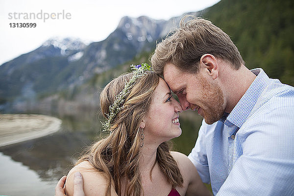 Nahaufnahme eines lächelnden jungen Paares  das sich bei einer Stirnberührung im Silver Lake Provincial Park von Angesicht zu Angesicht gegenübersteht