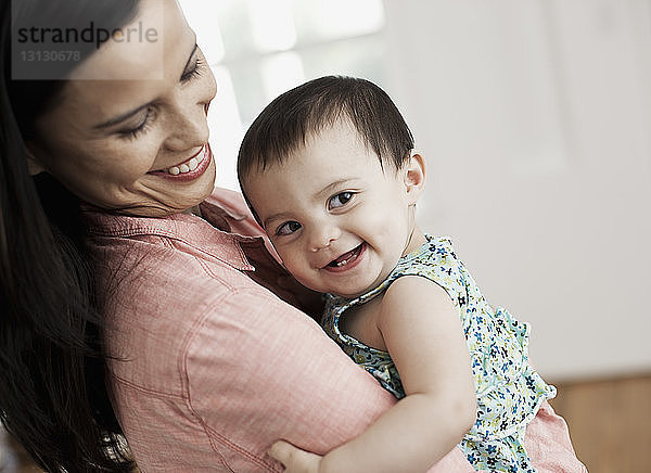 Lächelnde Mutter mit zu Hause stehender Tochter