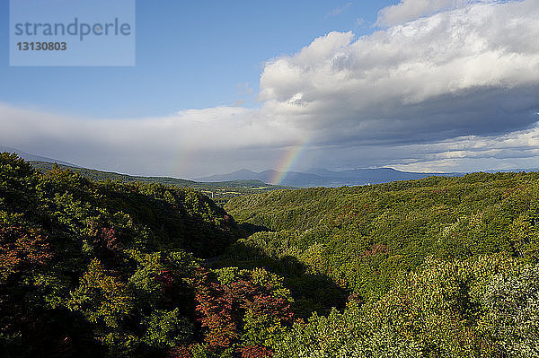 Landschaftliche Ansicht des Hakkoda-Gebirges gegen Regenbogen und bewölkten Himmel