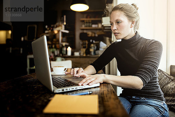 Junge Frau mit Laptop im Café