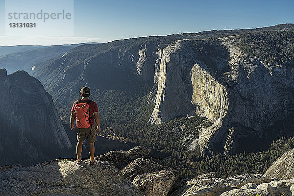 Rückansicht eines männlichen Wanderers  der auf einer Klippe im Yosemite National Park steht