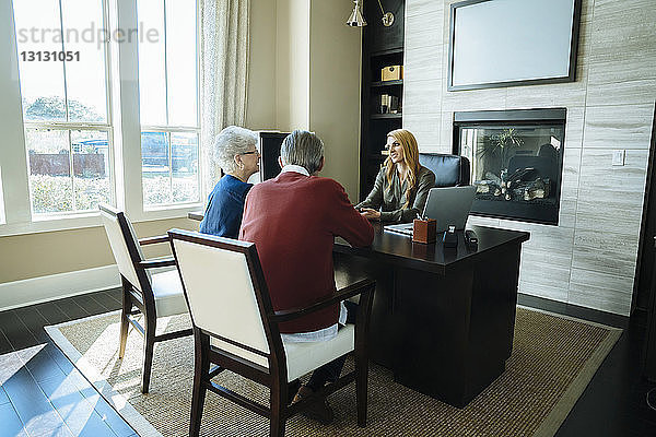 Älteres Ehepaar diskutiert im Büro mit Finanzberater