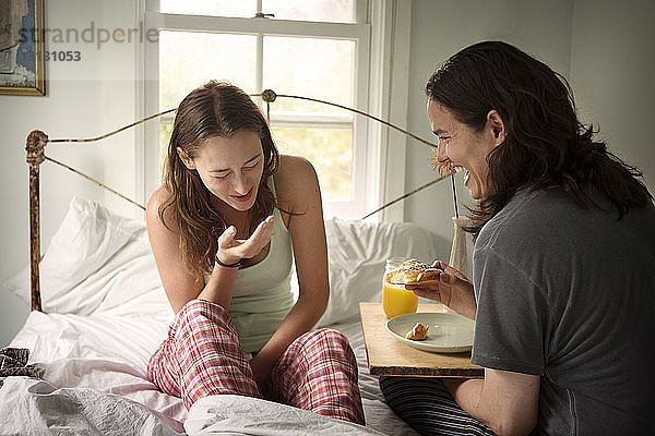 Glückliches Paar frühstückt am Bett