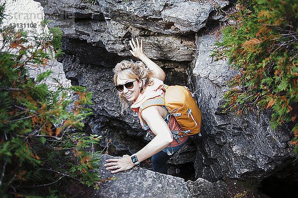 Hochwinkelporträt einer Wanderin mit Rucksack inmitten von Felsen im Bruce Peninsula National Park