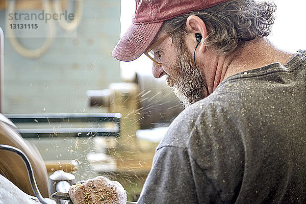 Rückansicht des in der Werkstatt arbeitenden Handwerkers