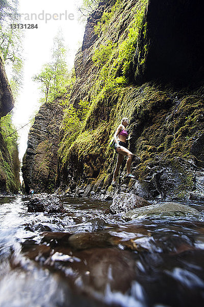 Wanderer besteigt Berg am Fluss