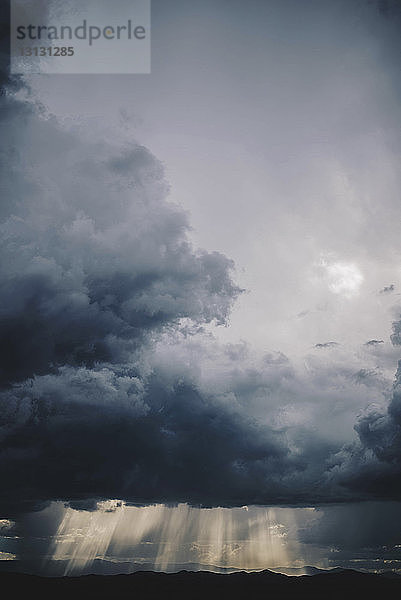 Szenische Ansicht von Gewitterwolken über den Silhouettenbergen