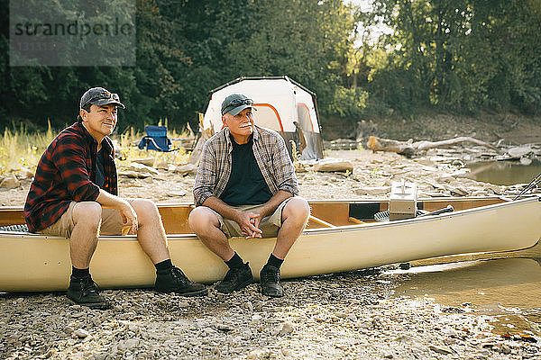 Freunde schauen weg  während sie auf dem Boot auf dem Campingplatz sitzen