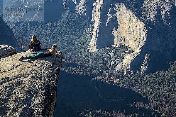 Hochwinkelaufnahme von Freundinnen  die sich auf einer Klippe im Yosemite-Nationalpark entspannen