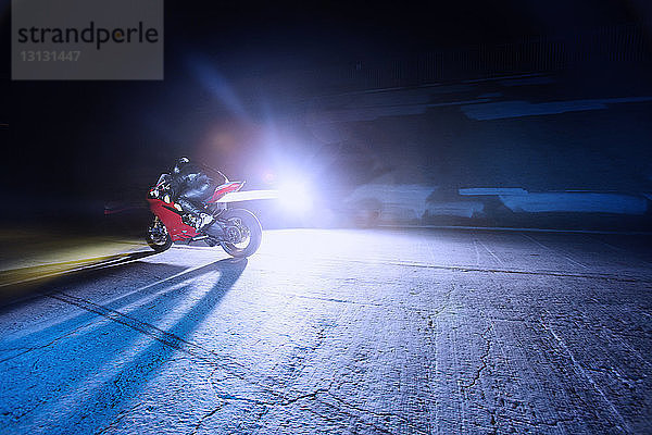 Motorradfahren auf der Straße bei Nacht