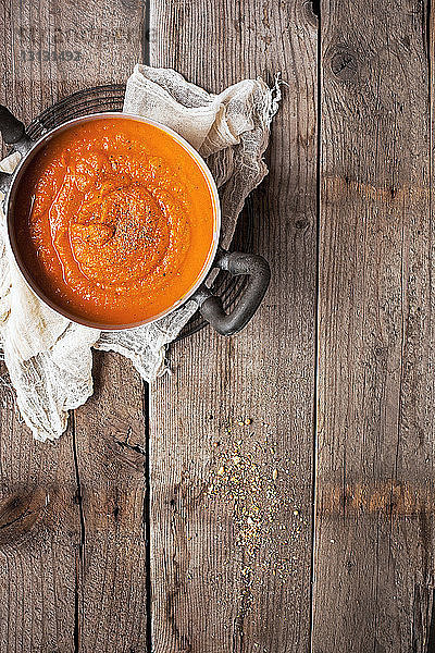 Draufsicht auf Karottensuppe auf Holztisch