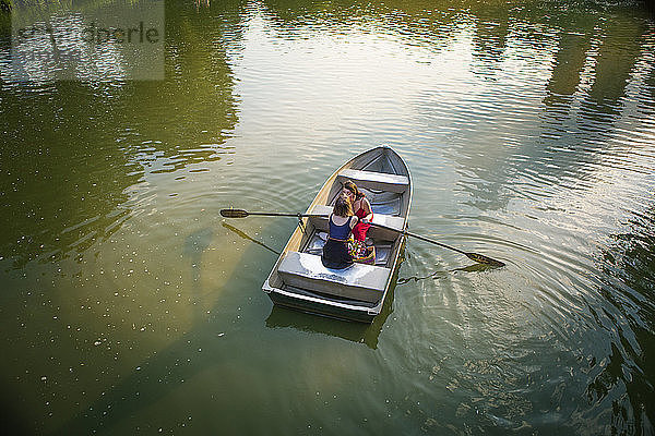 Draufsicht auf ein lesbisches Paar  das sich küsst  während es in einem Boot inmitten des Sees sitzt