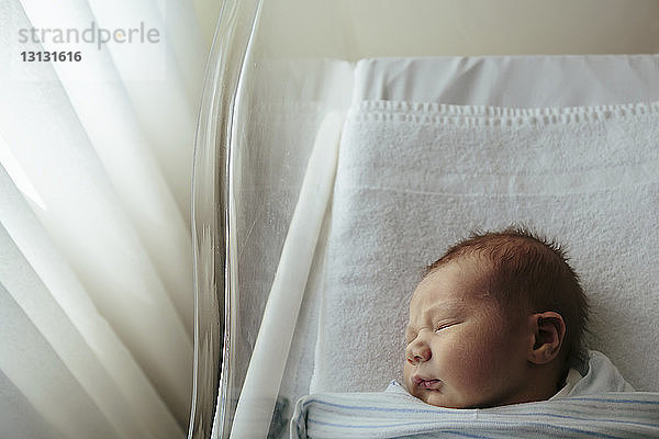 Draufsicht eines neugeborenen Mädchens  das im Krankenhaus in einem Kinderbett schläft